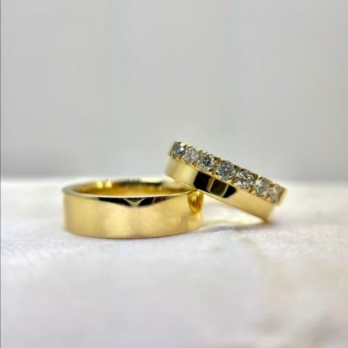 ALIANÇA EM MOEDA RODEADAS DE PEDRAS